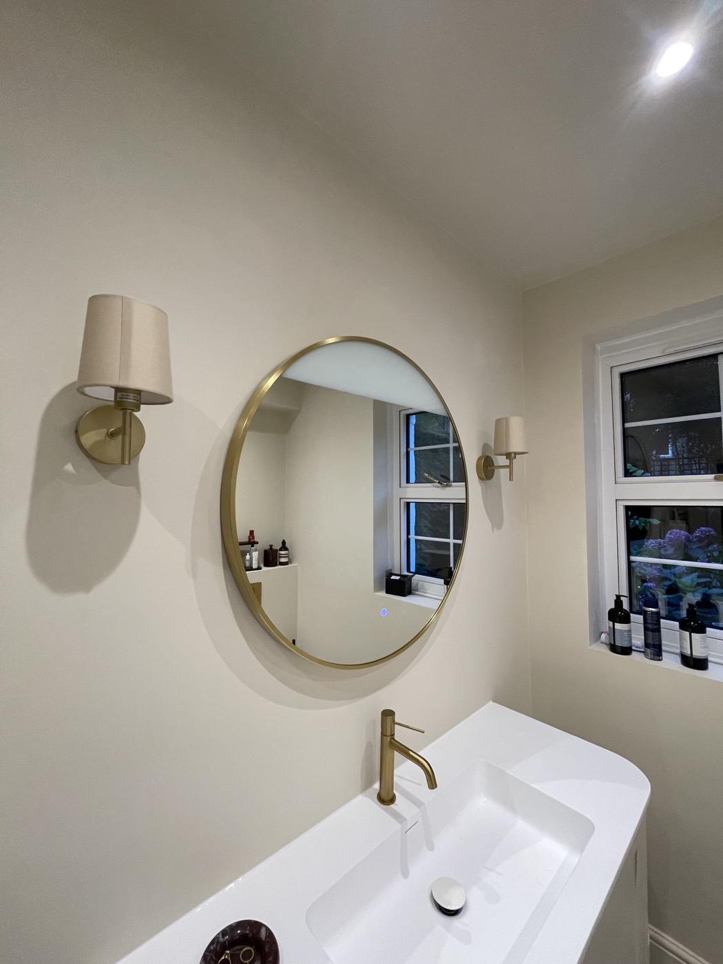 Wall-hung vanity unit with round brass mirror in a Shepherd's Bush W12 bathroom renovation