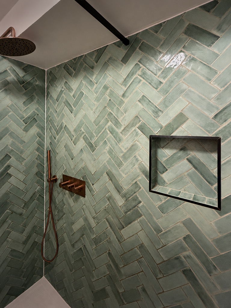 Green herringbone tiling and black-framed shower niche in a Streatham SW16 bathroom renovation