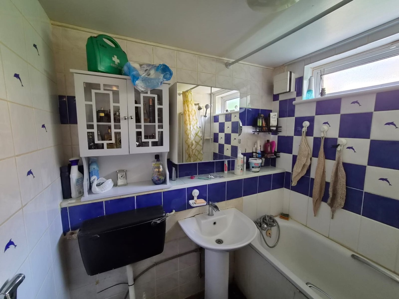 Woolwich SE18 bathroom before renovation — dated blue and white tiling with pedestal basin