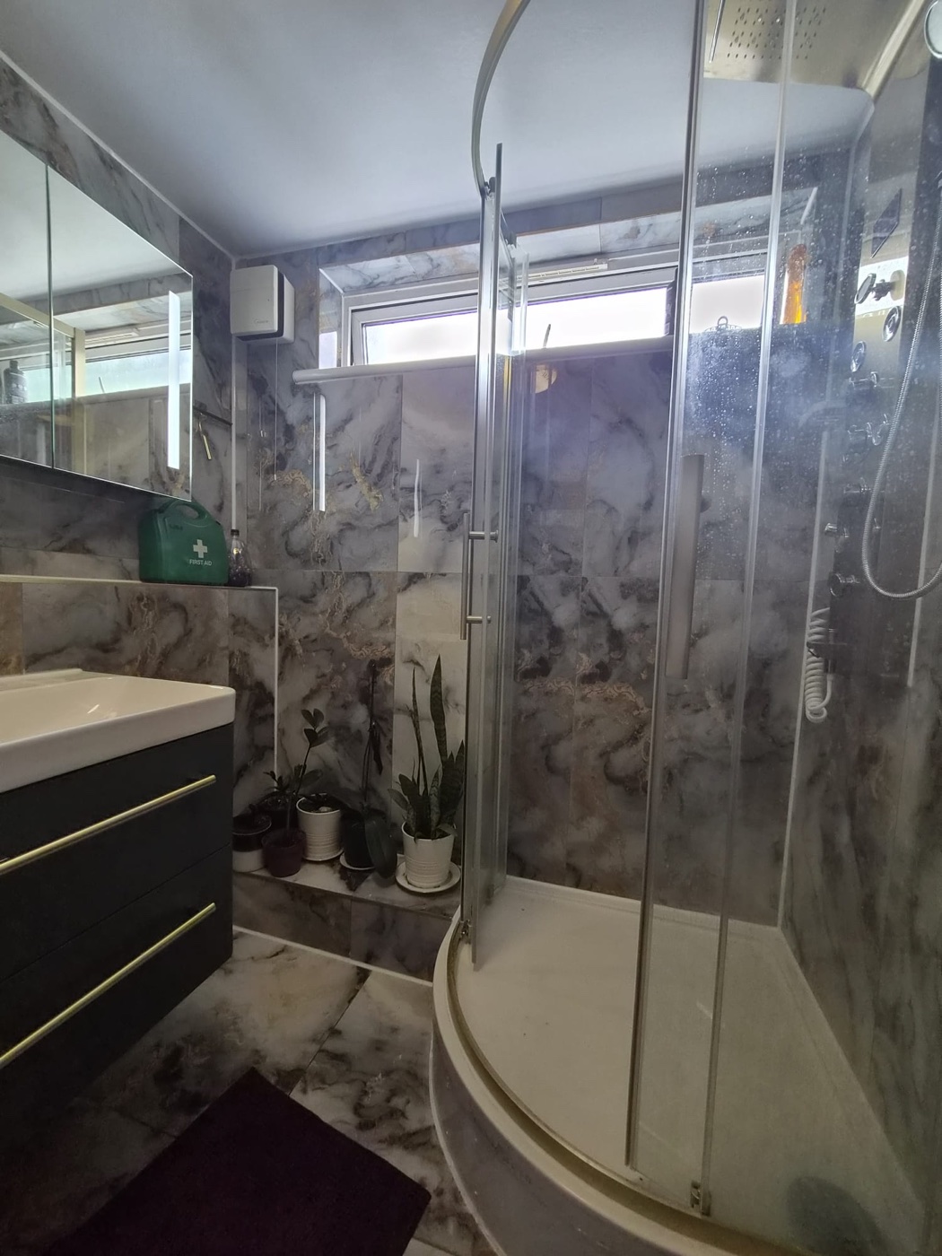 Marble-effect tiling and quadrant shower enclosure in a Woolwich SE18 bathroom renovation