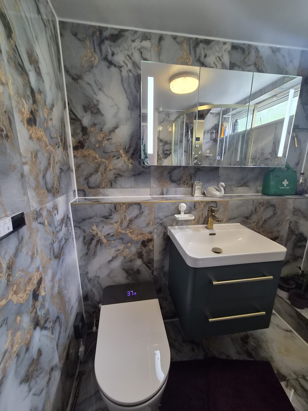 Wall-hung smart WC against gold-veined marble-effect tiling, Woolwich SE18